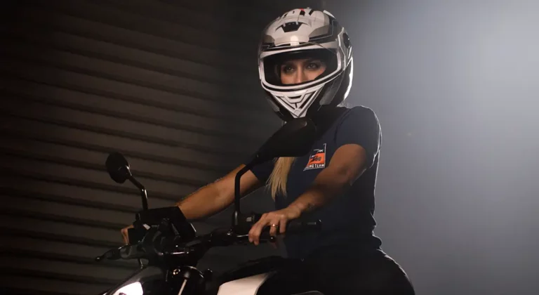 mulher em moto com capacete representando o que é direção defensiva